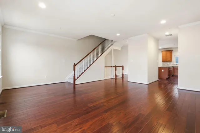 a view of empty room with wooden floor