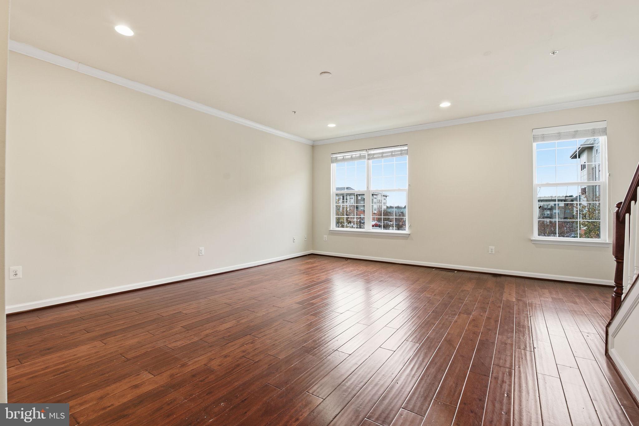 7025 Southmoor Street Hanover, MD 21076 - Photo 9 of 35 a view of an empty room with wooden floor and a window