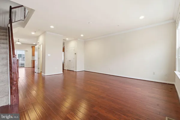 a view of an empty room with wooden floor