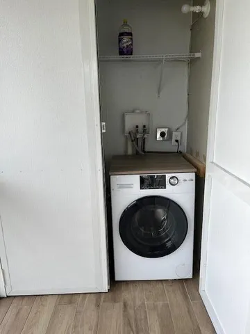 a utility room with wooden floor washer and dryer