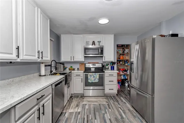 a kitchen with stainless steel appliances granite countertop a refrigerator and a stove