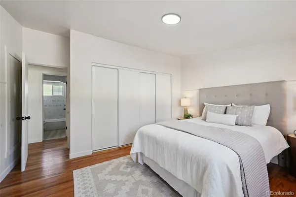 a bedroom with a bed and wooden floor