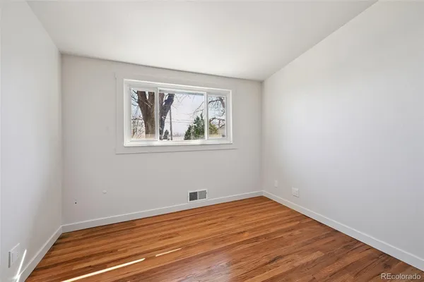 wooden floor in an empty room with a window