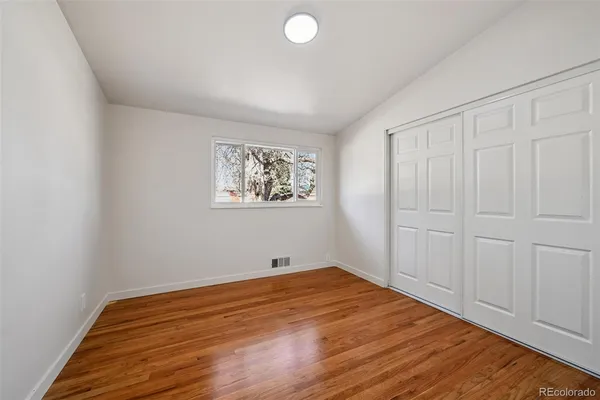 a view of empty room with wooden floor