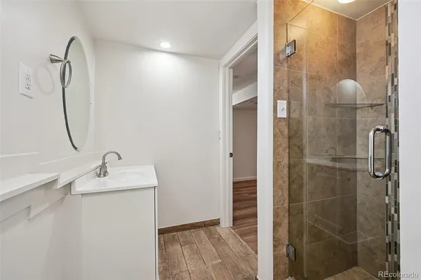 a bathroom with a shower sink and mirror