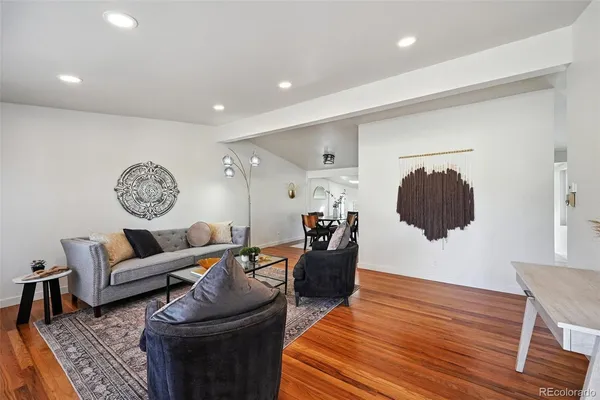a living room with furniture and a wooden floor