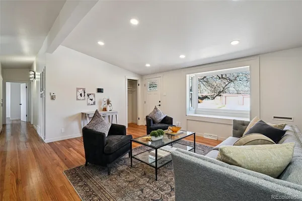 a living room with furniture and wooden floor