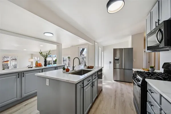 a kitchen with stainless steel appliances granite countertop a sink stove and refrigerator