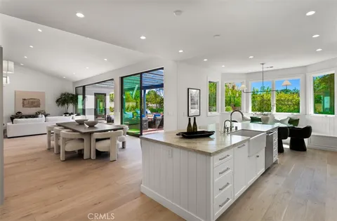 a large kitchen with kitchen island a large counter top space a sink a window and living room view