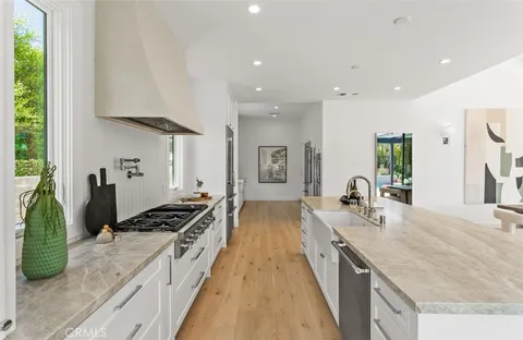 a large kitchen with stainless steel appliances granite countertop a lot of counter space and a sink
