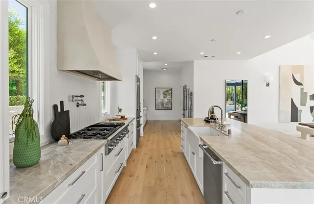 a large kitchen with stainless steel appliances granite countertop a lot of counter space and a sink