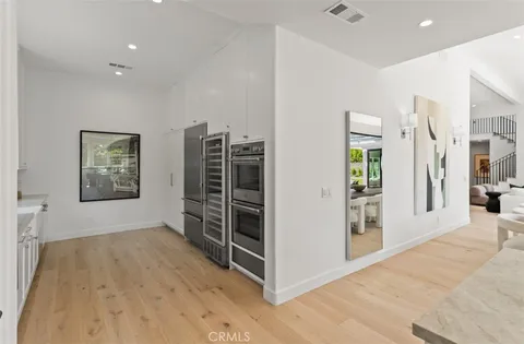 a view of empty room with wooden floor and windows