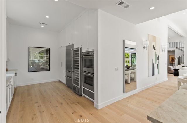 a view of empty room with wooden floor and windows