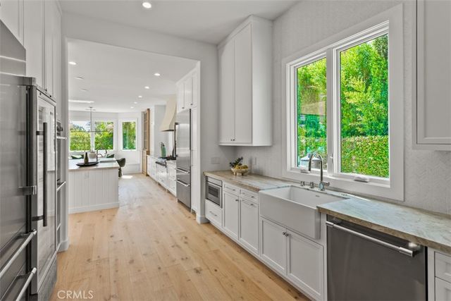 a large kitchen with a large window and stainless steel appliances