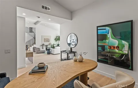 a living room with furniture a mirror and clock on the wall