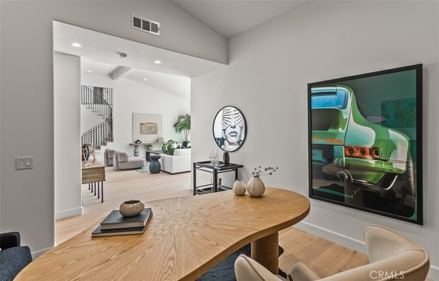 a living room with furniture a mirror and clock on the wall
