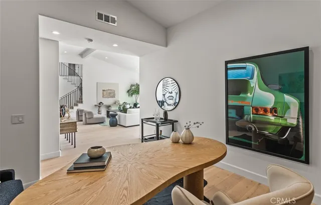 a living room with furniture a mirror and clock on the wall