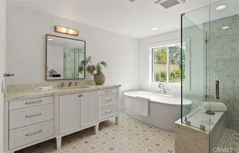 a spacious bathroom with a double vanity sink mirror and bathtub