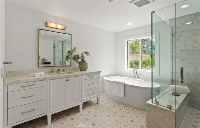a spacious bathroom with a double vanity sink mirror and bathtub