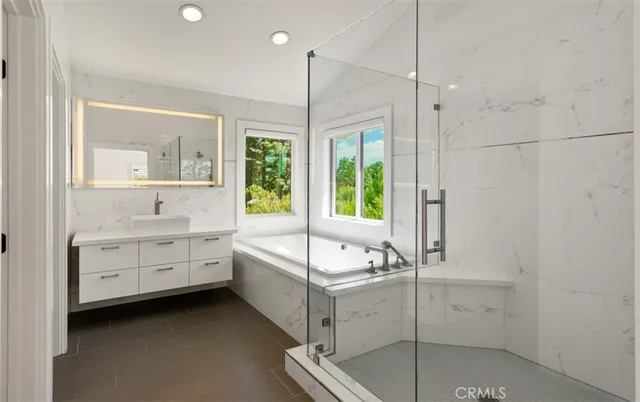 a bathroom with a tub sink and mirror