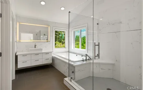 a bathroom with a tub sink and mirror