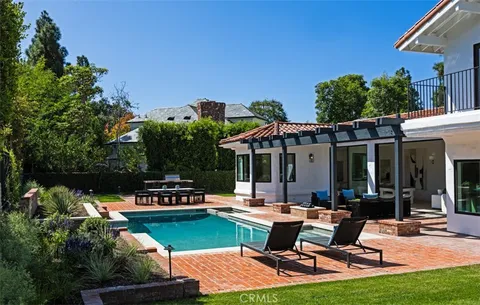 a view of a patio with table and chairs potted plants and palm tree