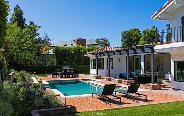 a view of a patio with table and chairs potted plants and palm tree