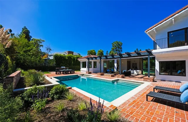a view of a house with swimming pool and sitting area