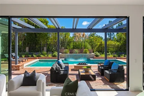 a living room with patio furniture and a floor to ceiling window