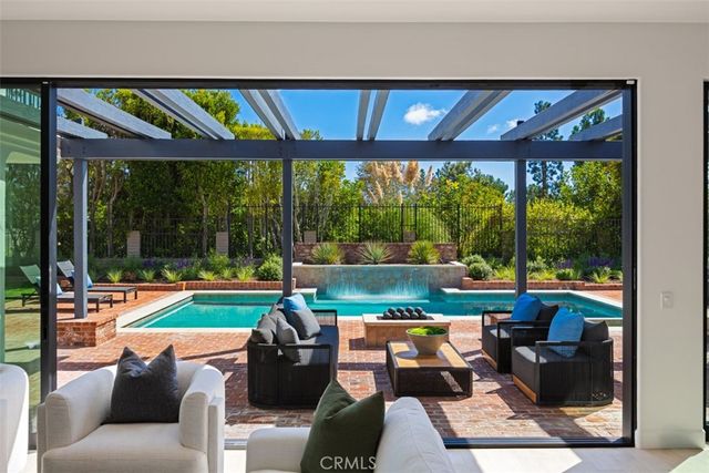 a living room with patio furniture and a floor to ceiling window