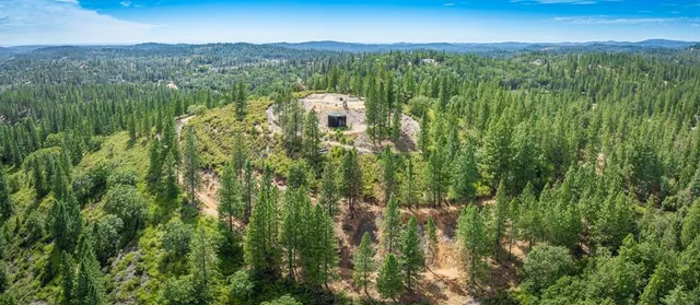 an aerial view of residential houses with outdoor space and trees