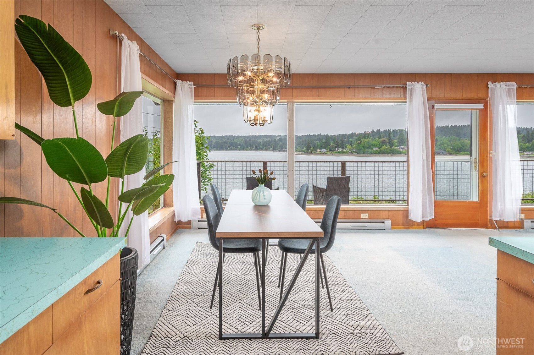 22617 Kingsbury Road Southwest Vashon, WA 98070 - Photo 12 of 29 a dining room with furniture a floor to ceiling window and a potted plant