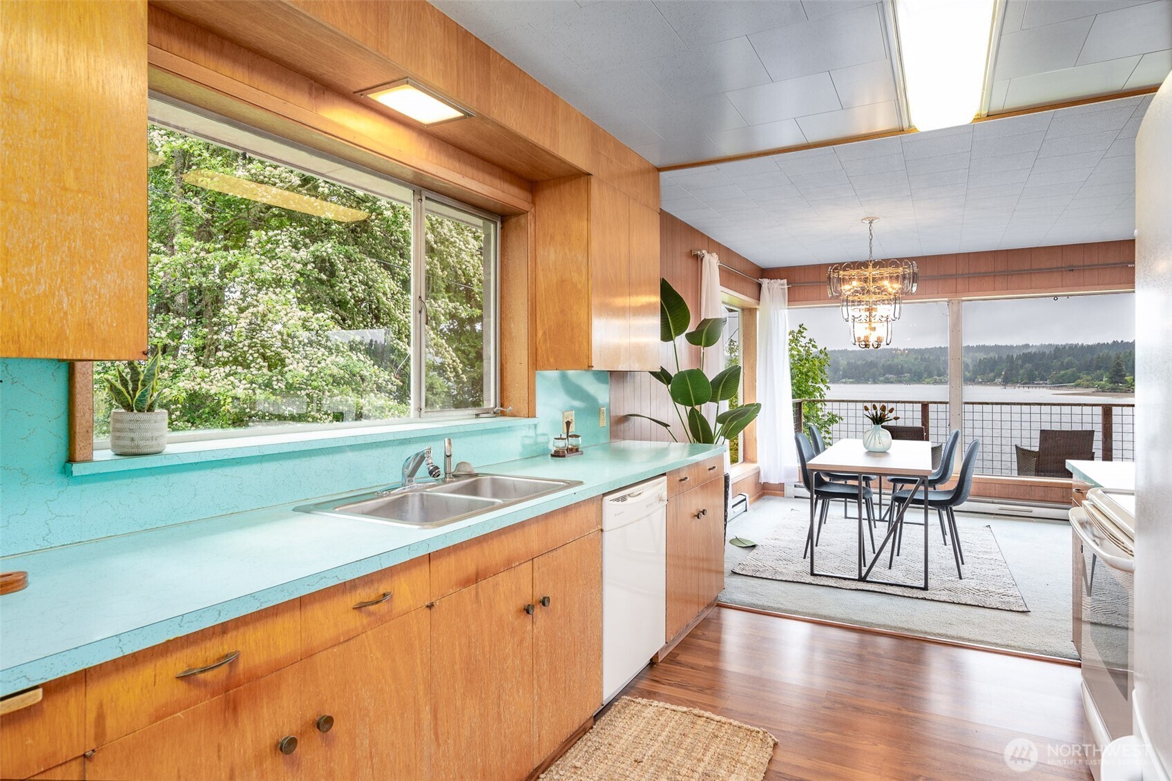 22617 Kingsbury Road Southwest Vashon, WA 98070 - Photo 13 of 29 a dining room with stainless steel appliances granite countertop a stove a sink and a dining table with garden view