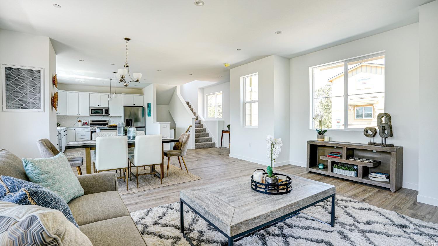 a living room with furniture kitchen view and a window