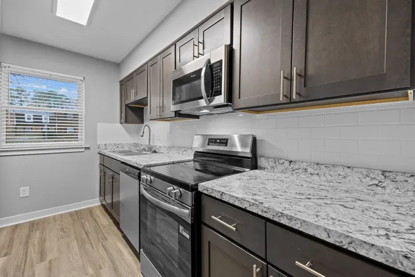 a kitchen with stainless steel appliances granite countertop a sink stove and microwave