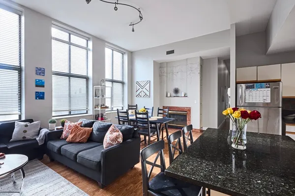 a living room with fireplace furniture and a large window