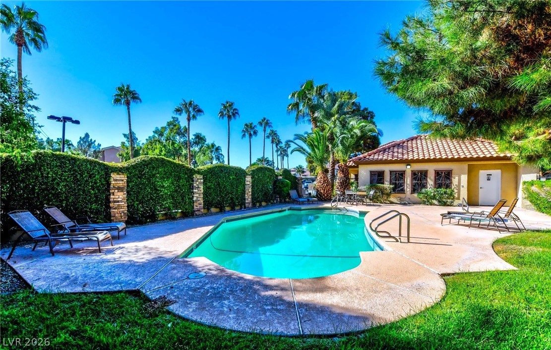 3135 South Mojave Road, Unit 156 Las Vegas, NV 89121 - Photo 16 of 18 A refreshing outdoor pool, nestled among mature palm trees, offers a serene oasis for relaxation and leisure.