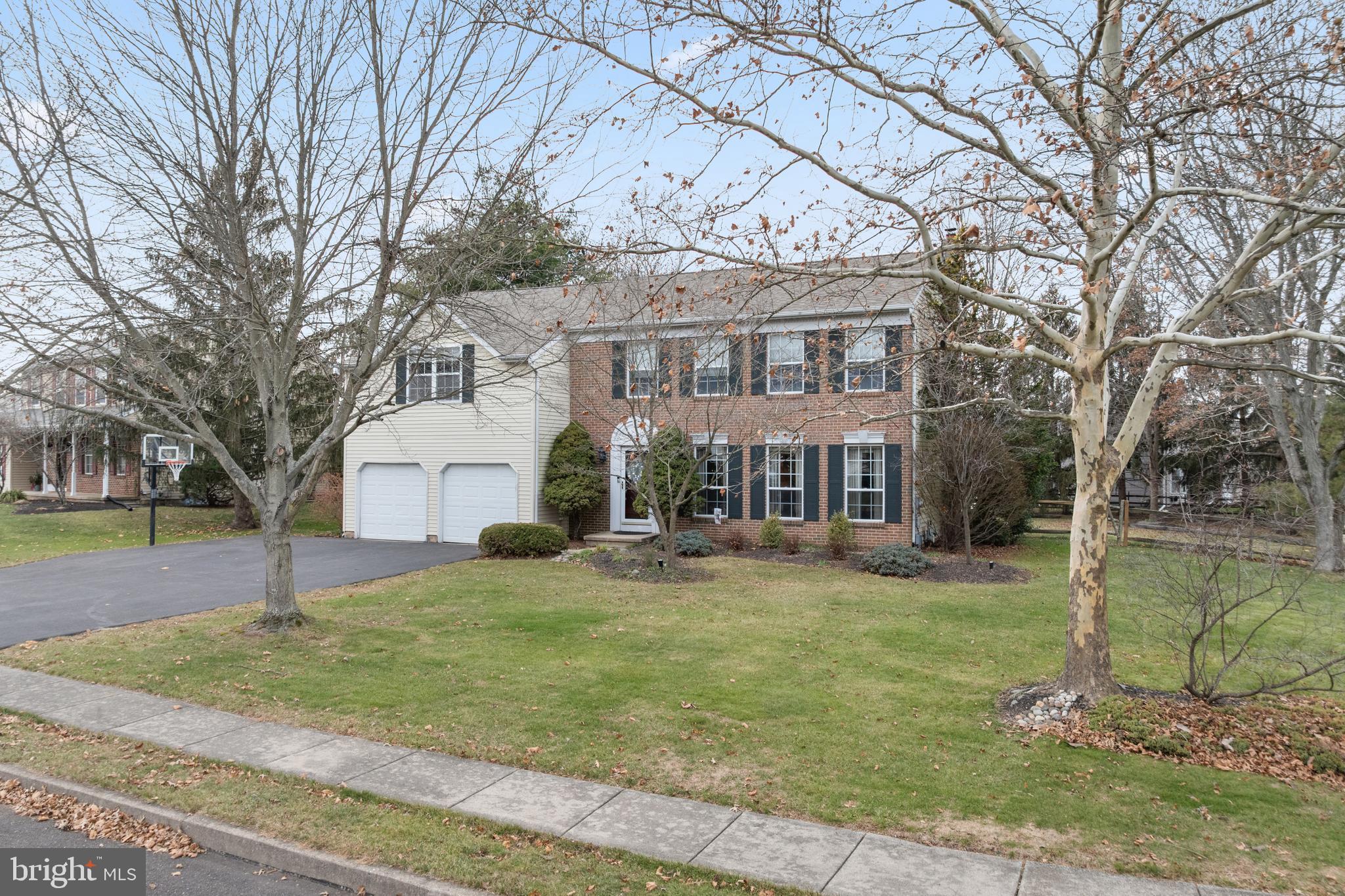 a view of a big house with a big yard and large trees