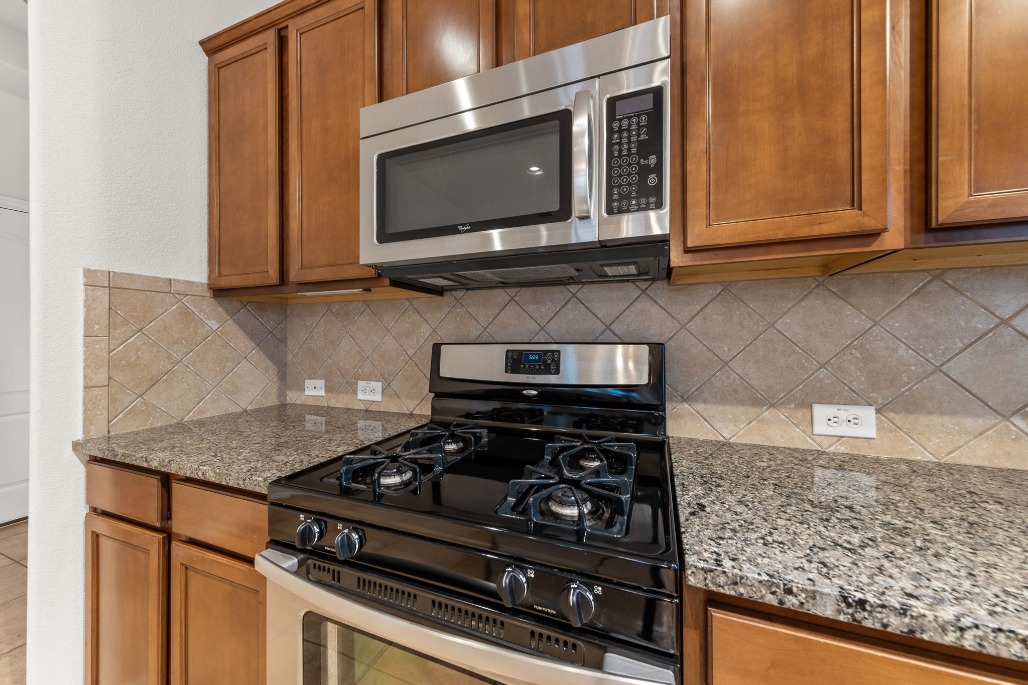 411 Tascate Street Georgetown, TX 78628 - Photo 12 of 41 Granite counters and stainless steel appliances elevate this kitchen's functionality.