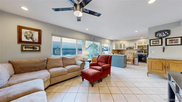 a living room with furniture kitchen view and a large window