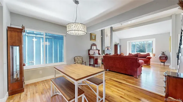 a view of a dining room with furniture a chandelier and wooden floor