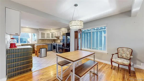 a living room with furniture a table and kitchen view