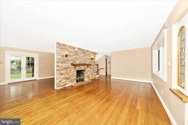 a view of empty room with wooden floor and fireplace