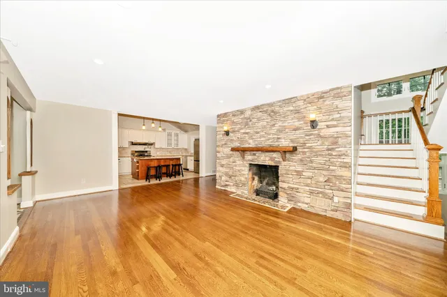a view of a livingroom with wooden floor and a fireplace