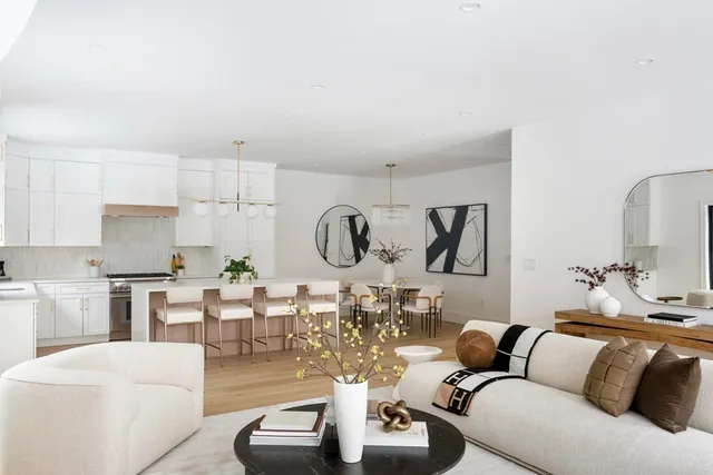 a living room with furniture kitchen view and a chandelier