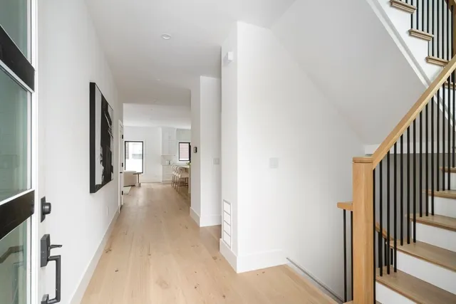 a view of a hallway with wooden floor and staircase