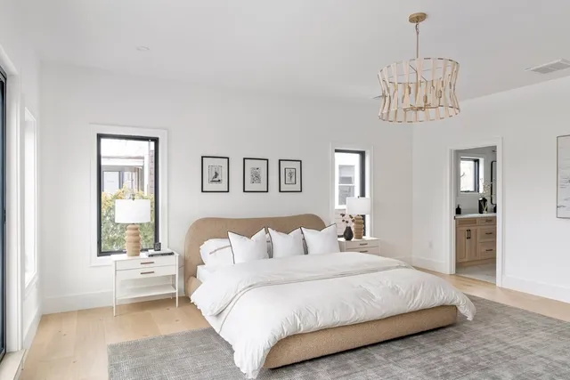 a bedroom with a large bed and a chandelier