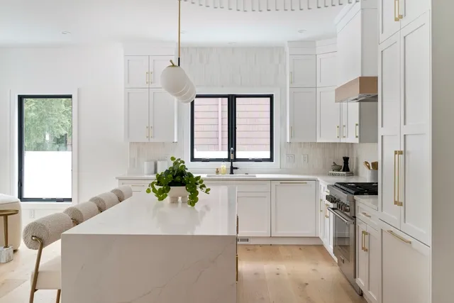 a kitchen with a white stove top oven and white cabinets