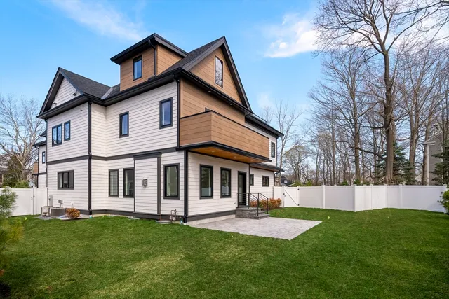 a front view of a house with a yard and trees