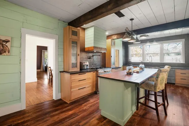 a view of a kitchen area with furniture and wooden floor